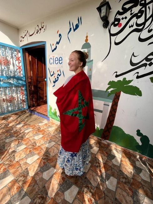 The author of the piece wrapping the Moroccan flag around herself in front of the CIEE Rabat office