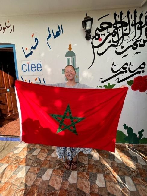 The author of the post holding the flag in front of the CIEE Rabat office