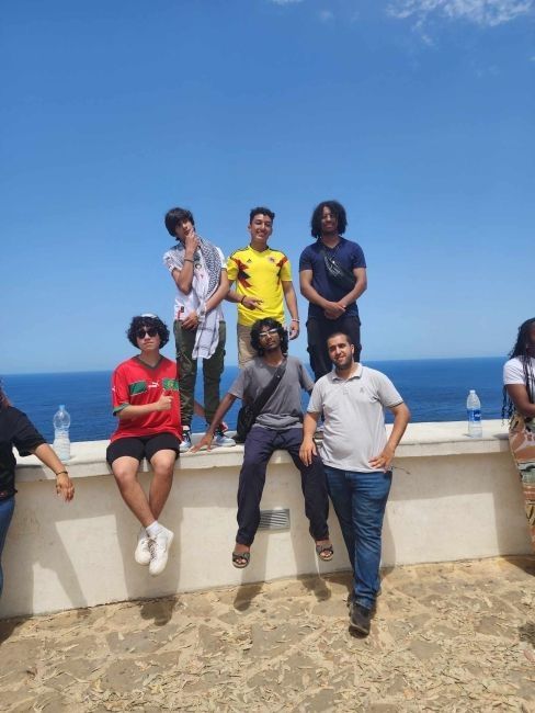 Students posing for picture in front of a view where the Mediterranean Sea meets the Atlantic Ocean