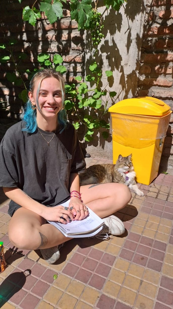 January term student completing an assignment at our local campus along with the campus cat, Kucha