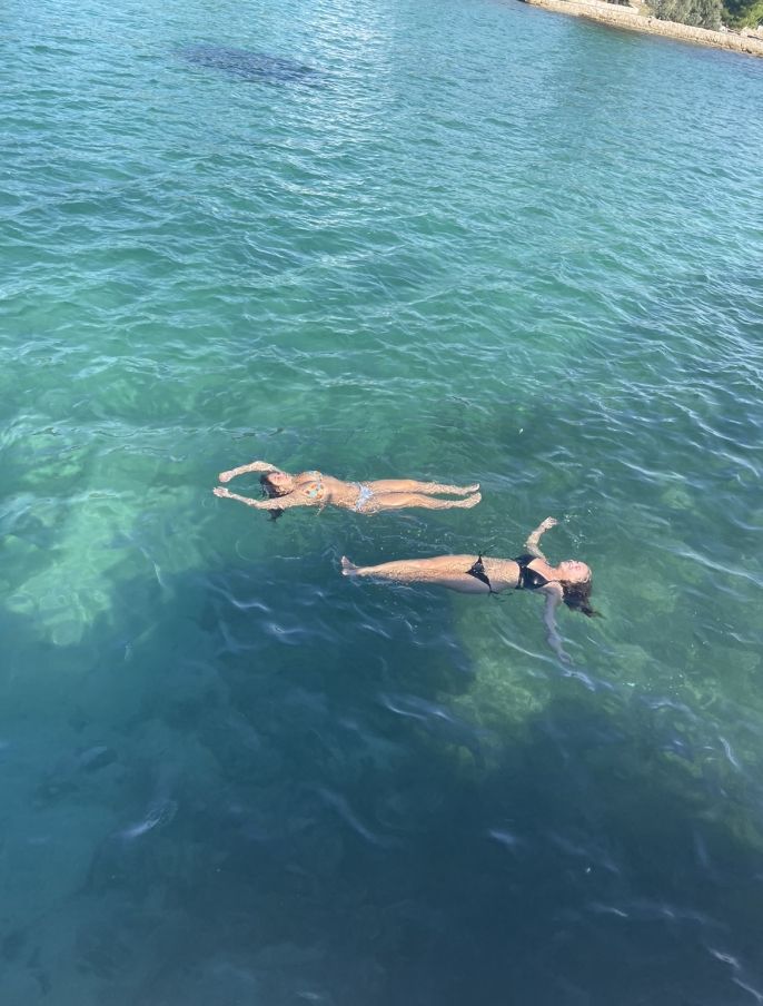 students abroad swimming clear blue water