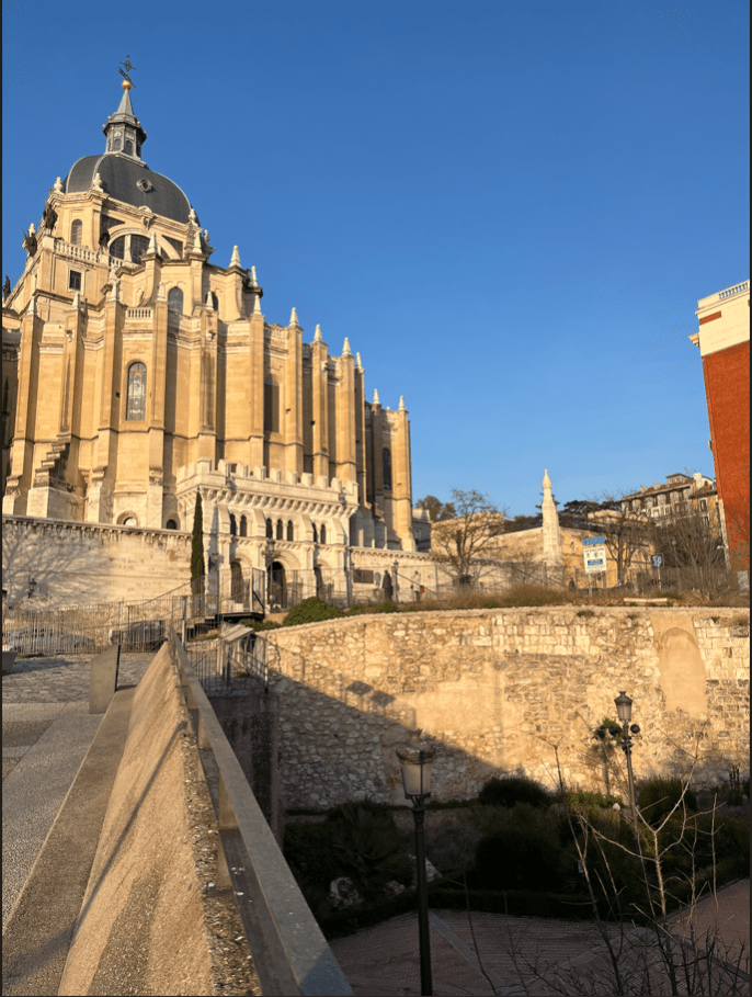 A cathedral rises behind an old wall