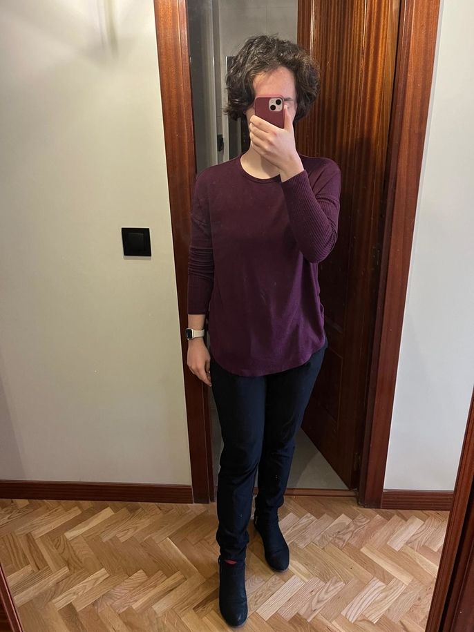 Wearing a red long-sleeved shirt and black jeans