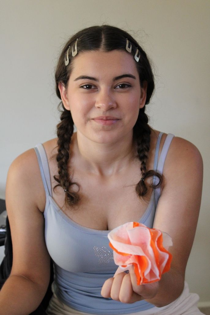 student holding paper flower