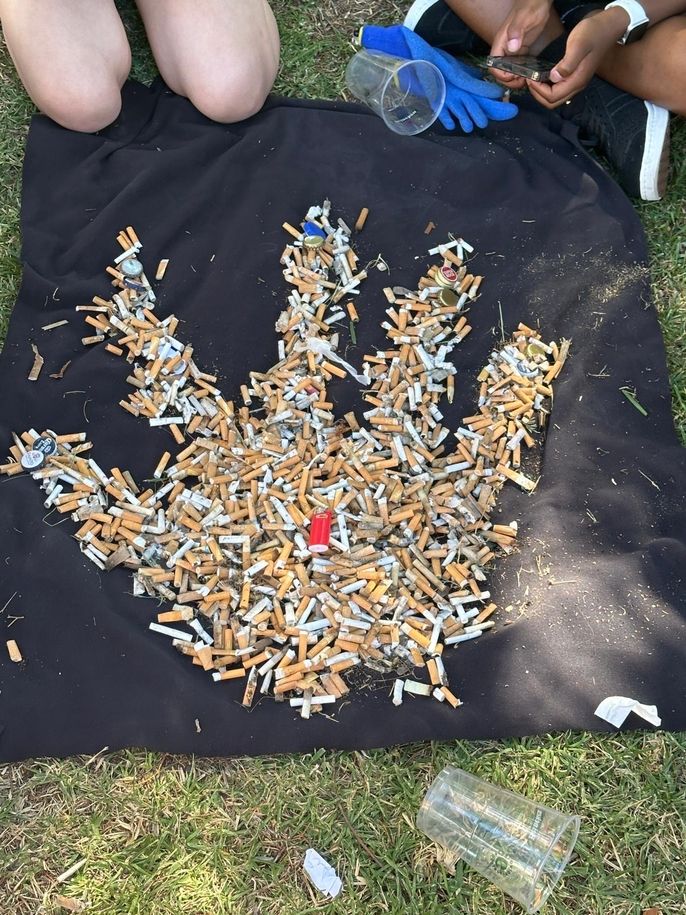 Cigarette art of a hand on top of a black towel. 