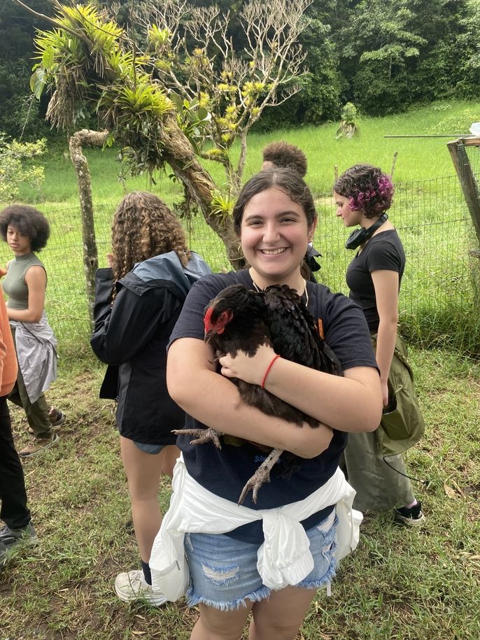 A Global Navigator holds on to one of the campus chickens.