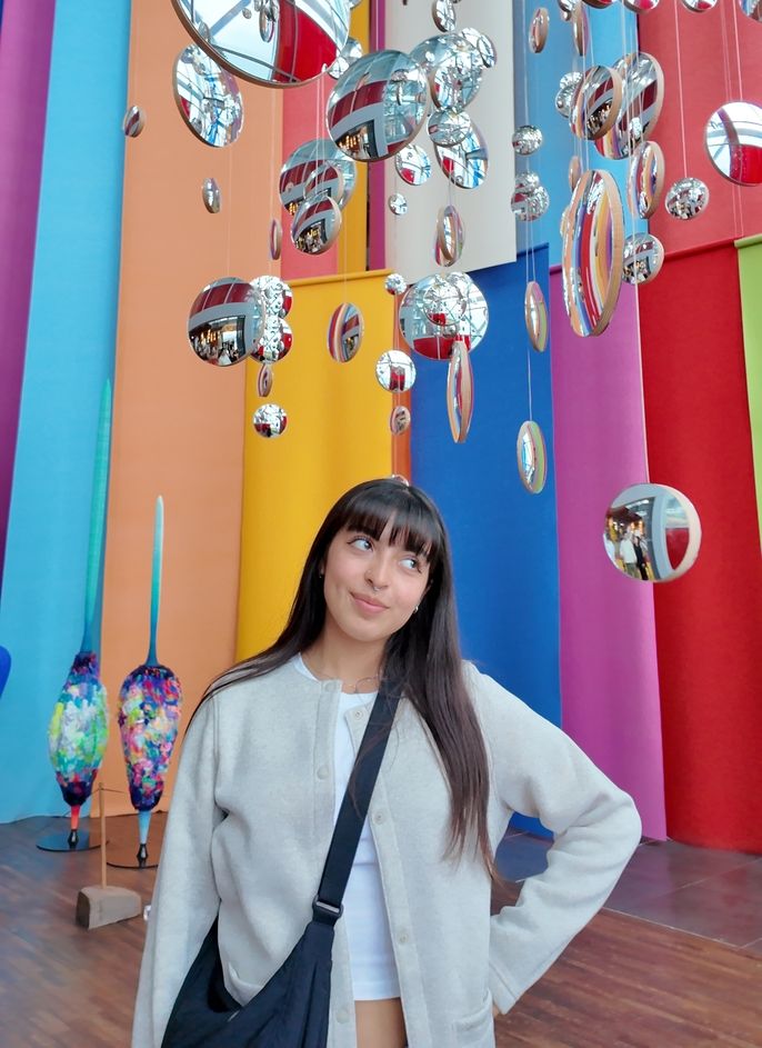 Author posing in front of color art installation