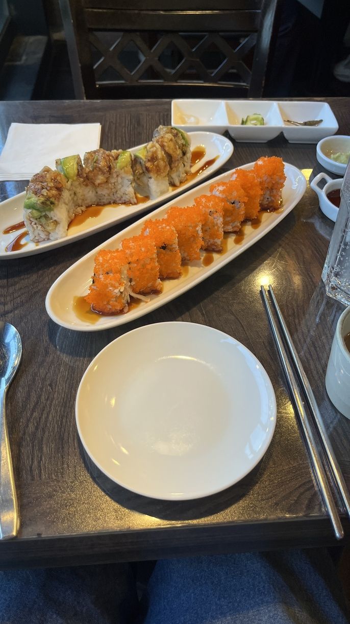 A picture of a table with two sushi rolls layed out