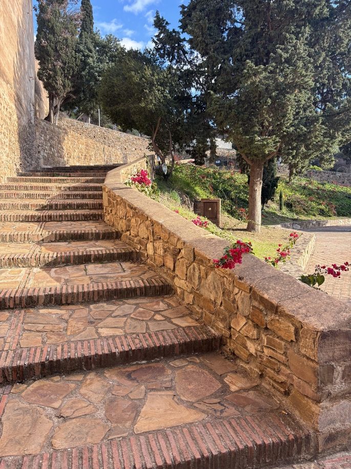 Stone stairs and a garden inside the Castillo de Gibralfar in Málaga, Spain.