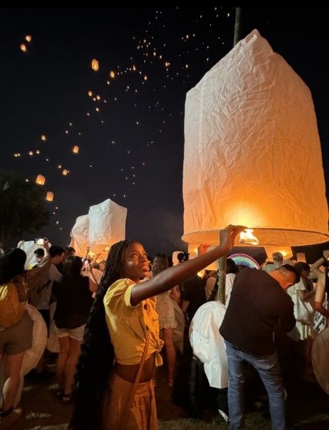 Me holding a lantern with many other lanterns lighting up the sky for the Loy Krathong festival 