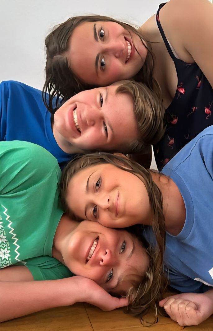 Four Smiling Faces Look at the Camera