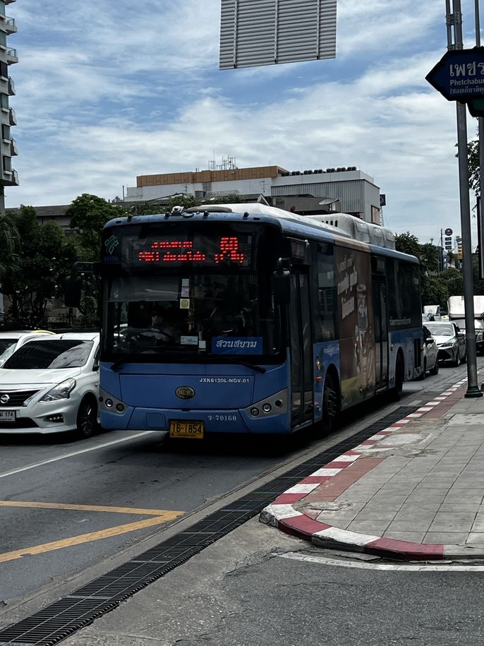 an image of a blue public bus in bangkok as it rides down the street