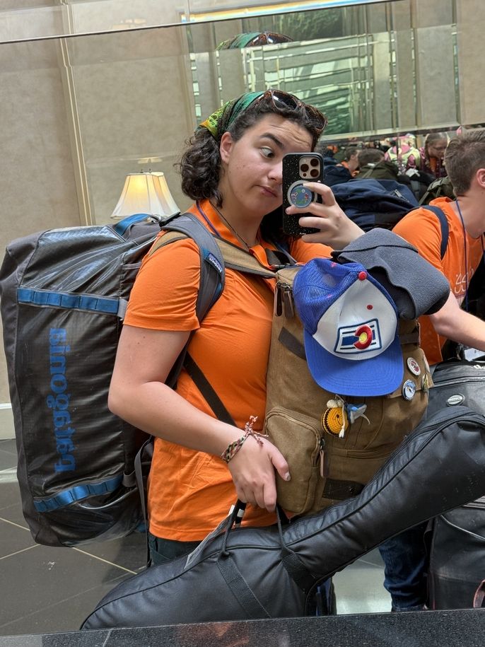 Emiko carrying two backpacks and a guitar in the airport