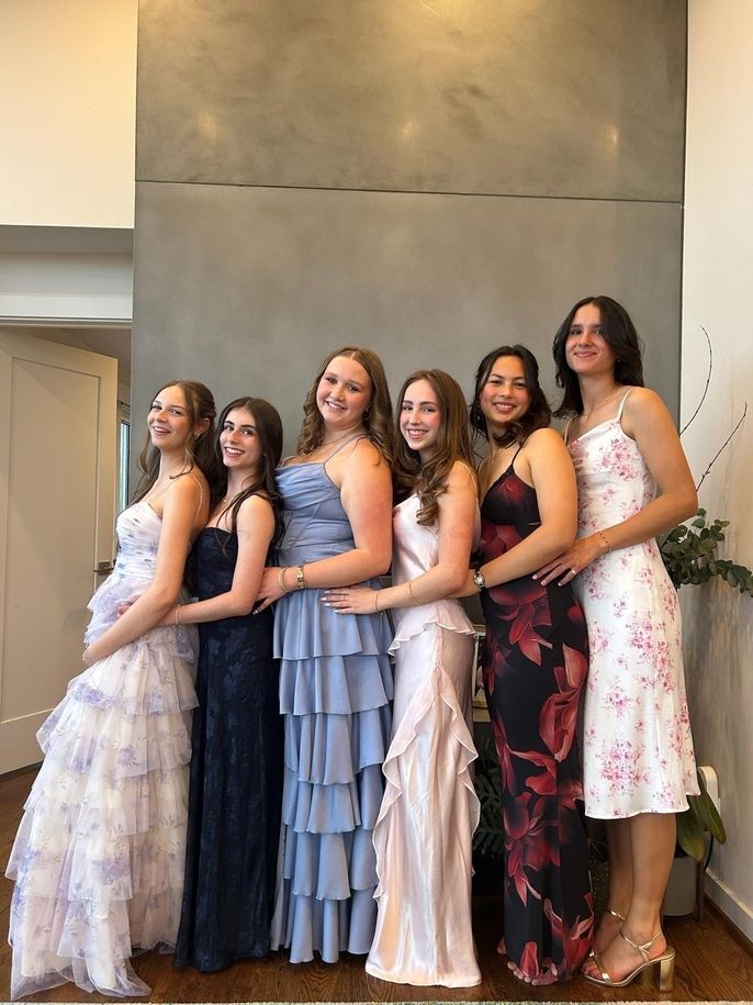 Izzy M. poses with friends in their formalwear.