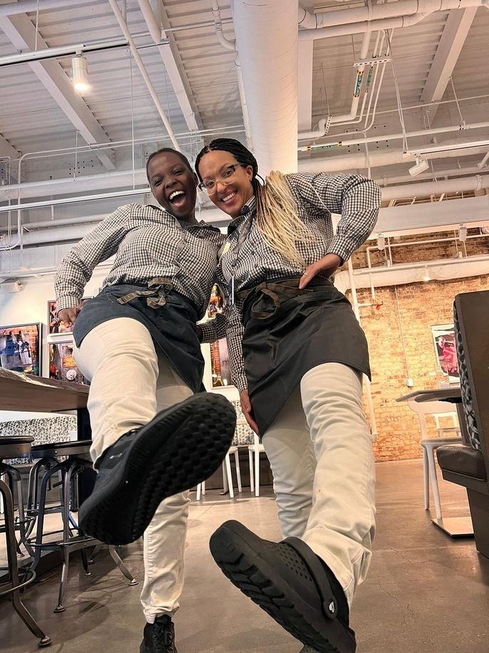 Naomi poses with a friend at work.