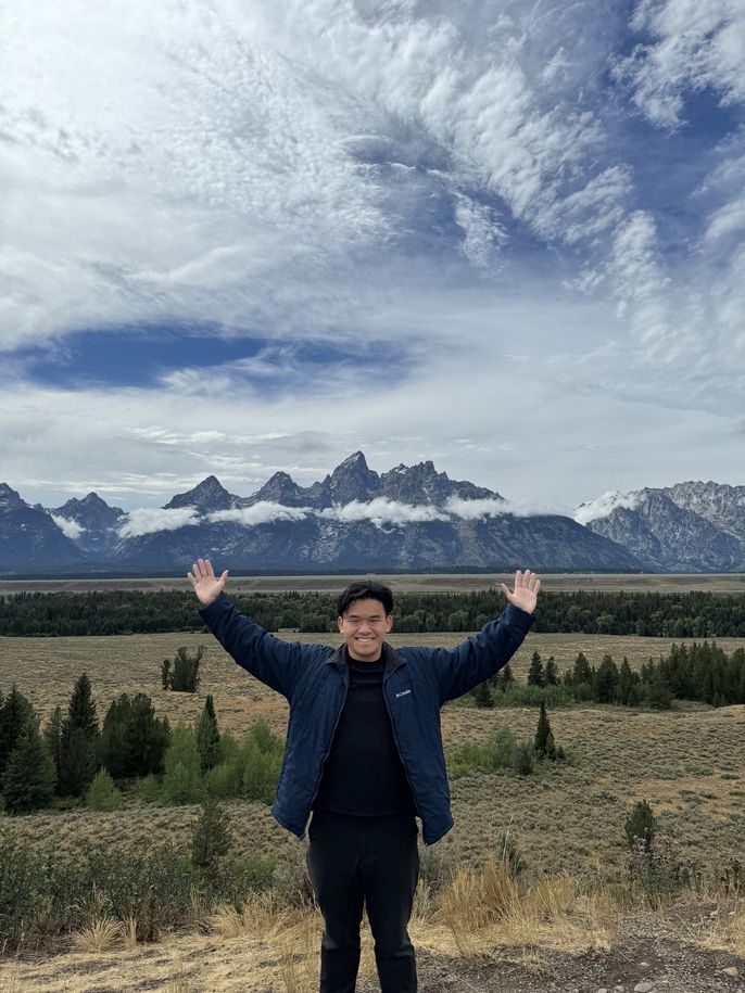 Yip Hern stands in front of Grand Teton National Park.