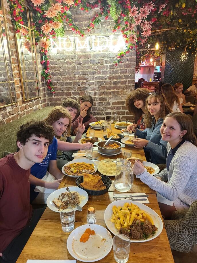 Students sit around a table at the welcome dinner