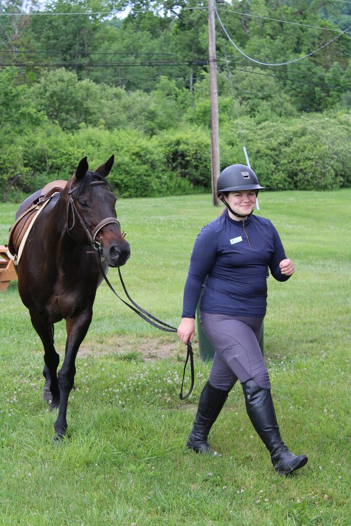 Venla S. of Finland leads a horse at a summer camp in Connecticut.