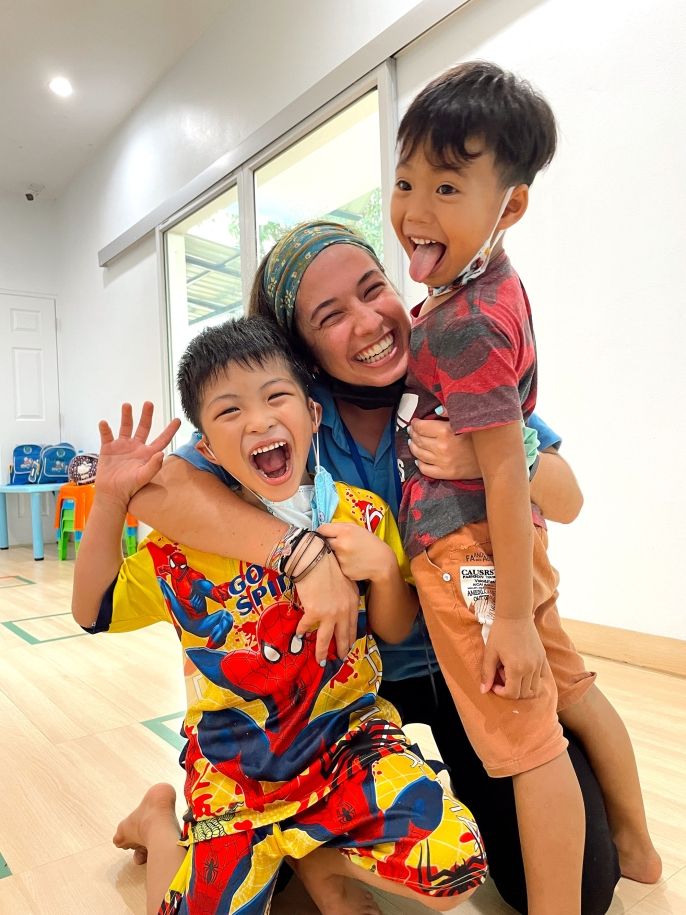 Teacher and students smiling and hugging