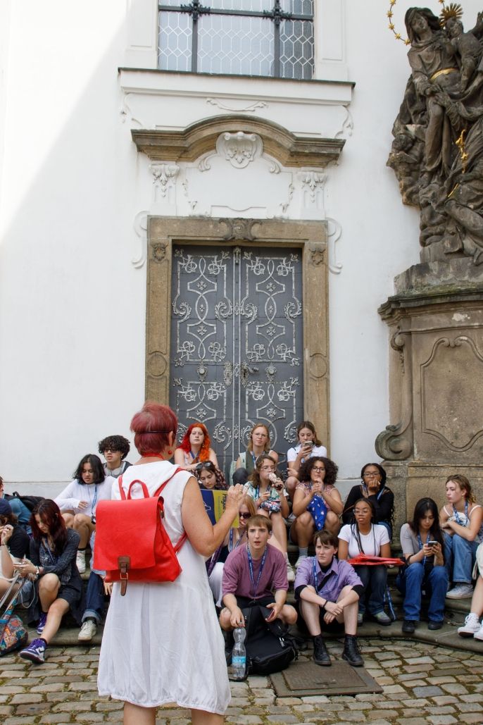 Teacher giving lecture to students on cobbled streets of Prague