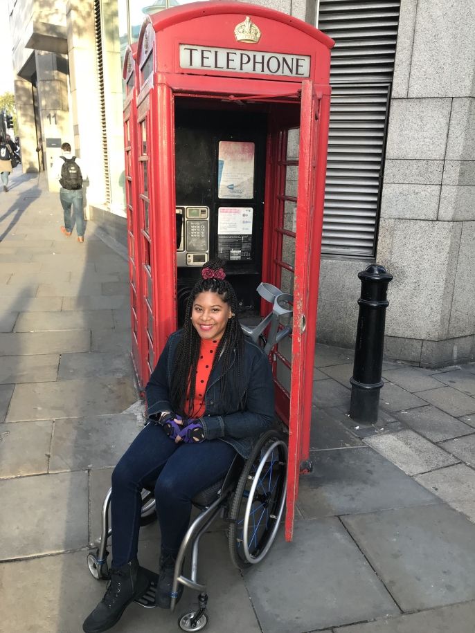 London student in wheelchair in front of phone booth