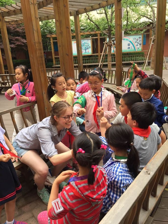 Teacher outside with students in a group huddle