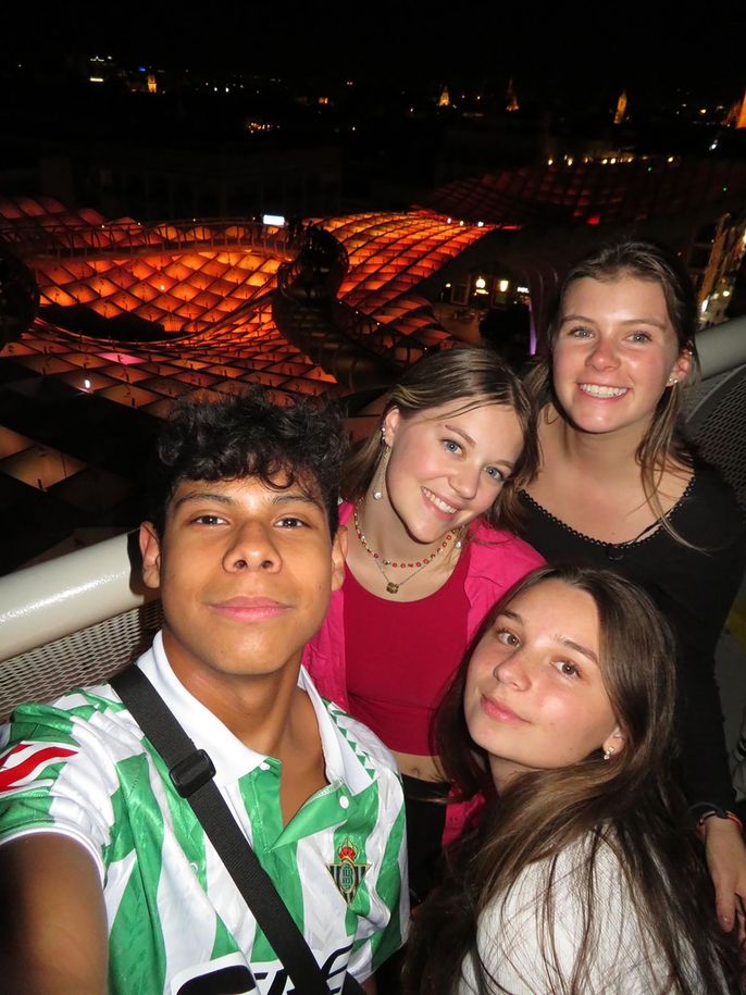 High schoolers smiling together in a group while studying abroad