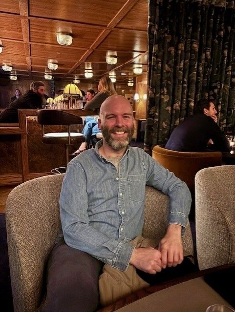 a man sits in a seat in a restaurant smiling
