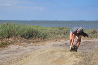 Maddie collecting trash on a beach