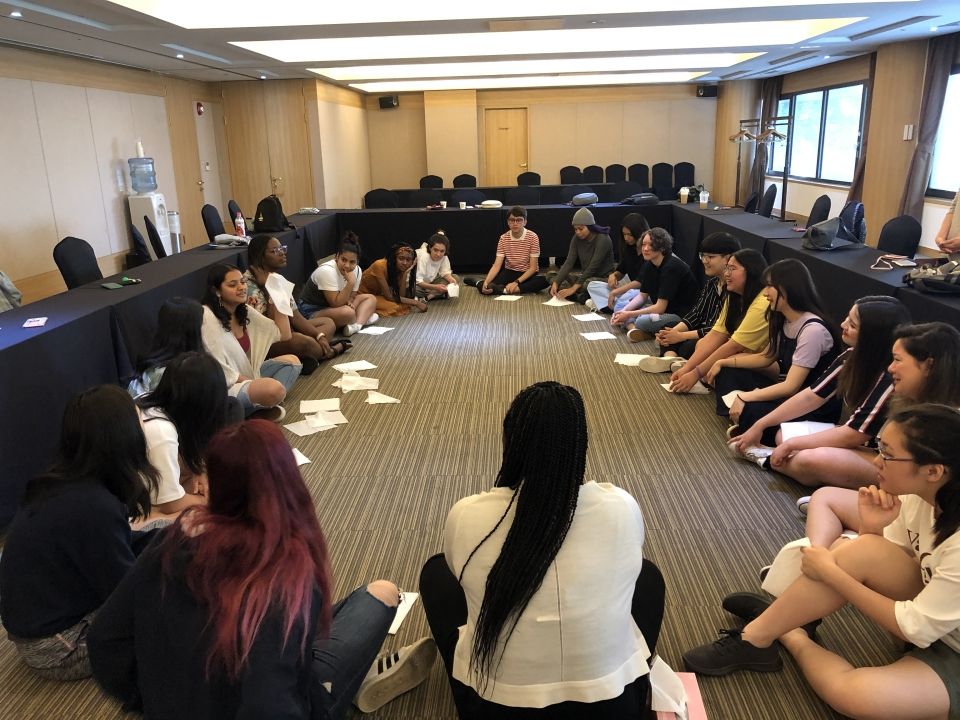 Students sitting in a circle participating in icebreaker activities.