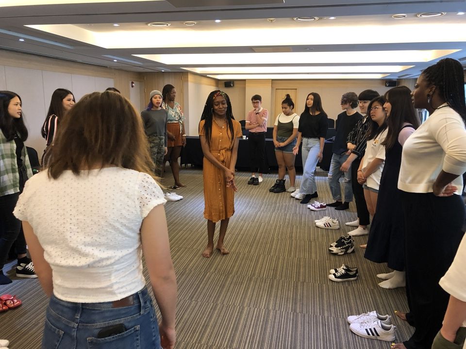 Students standing in a circle playing the game "The Wind Blows If"