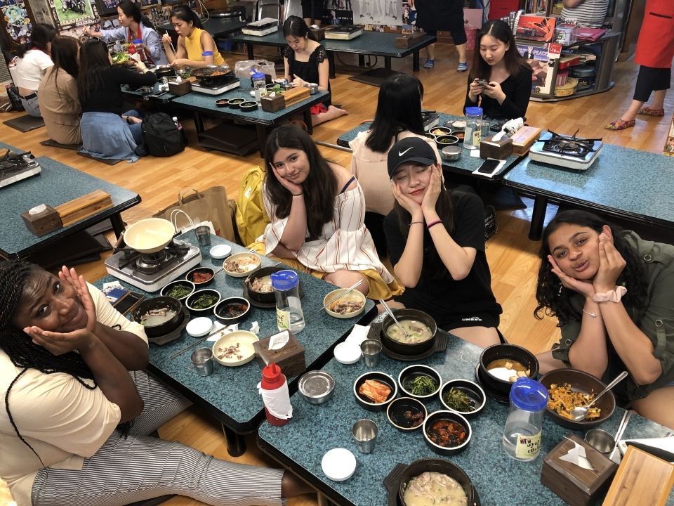 People posing at a table in a Samgyetang restaurant.
