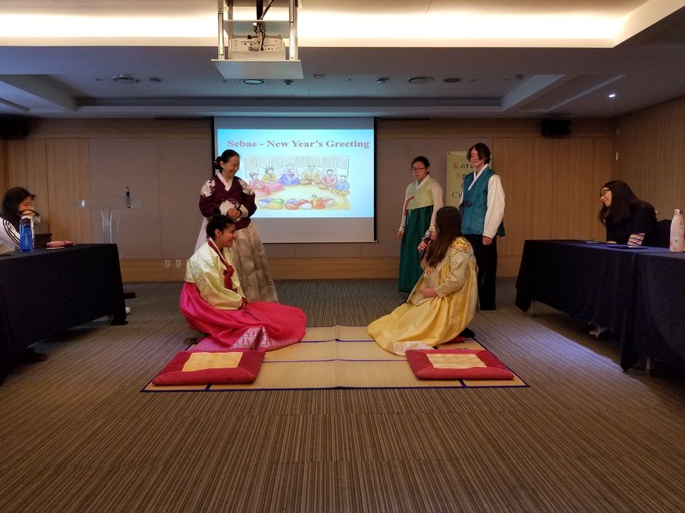 Students bowing while wearing Korean traditional dress