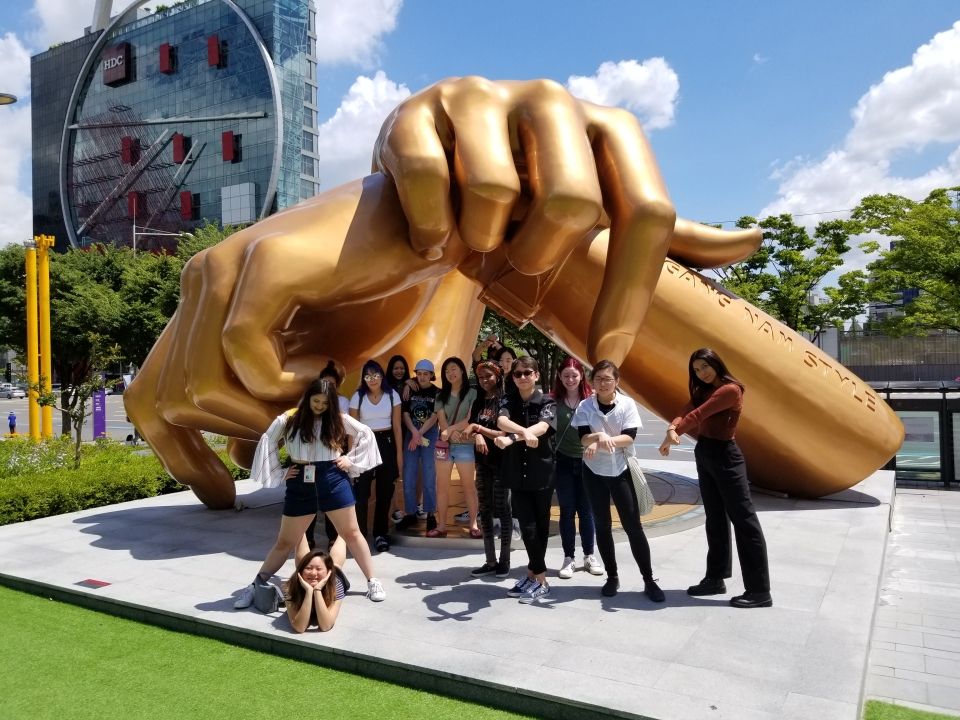 Students posing in front of the "Gangnam Style" statue.