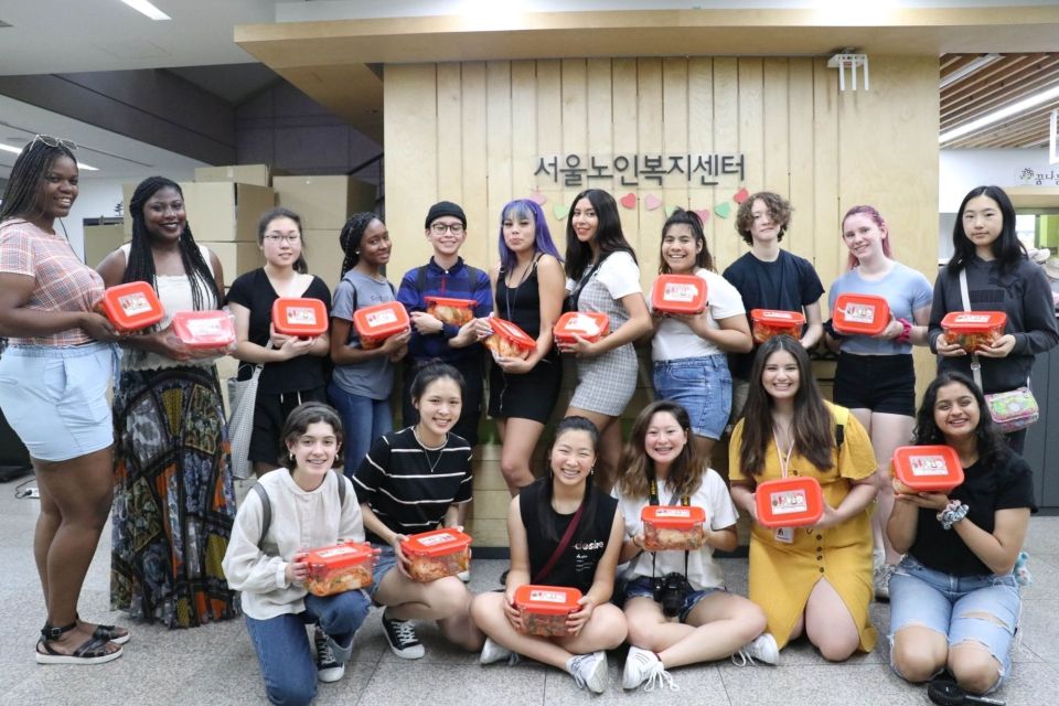 Students and program leaders holding containers of Kimchi inside a senior center.