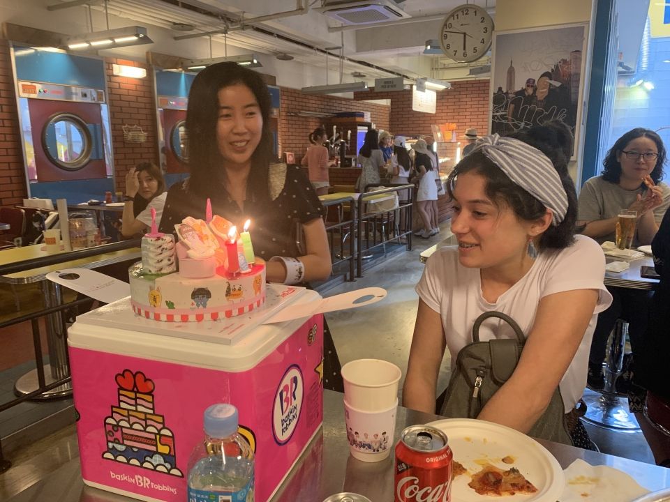 The birthday girl blowing out the candles of her birthday cake.