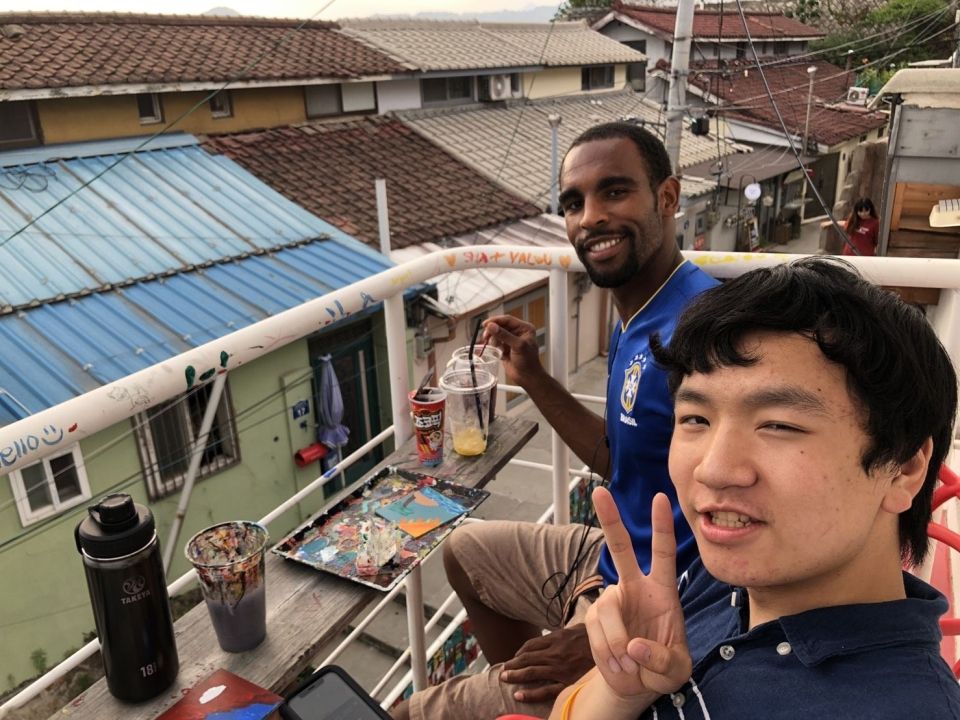 Student and program leader sitting on the rooftop of a cafe in Iwha Mural Village.