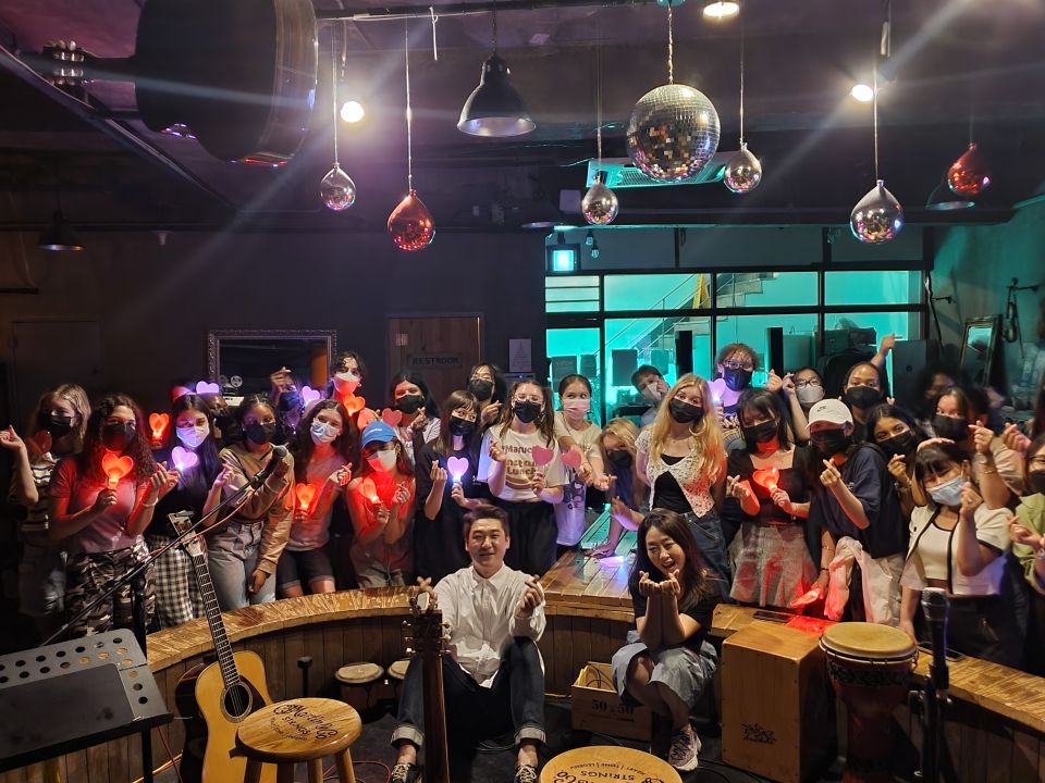 Students posing with Jungheum Band after a performance