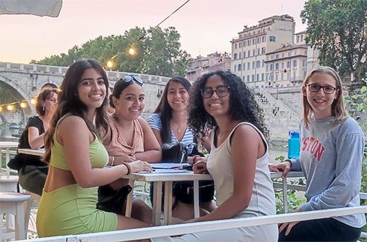 study abroad students eating dinner in rome by the river