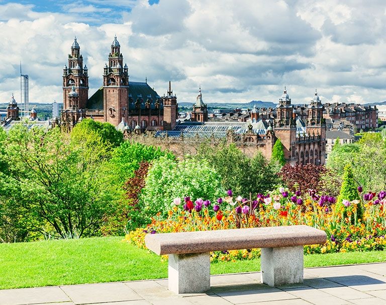 bench with flowers and view of city of glasgow