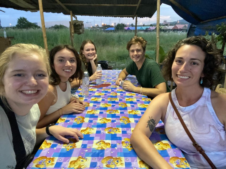 Group of people smiling around a dinner table. 