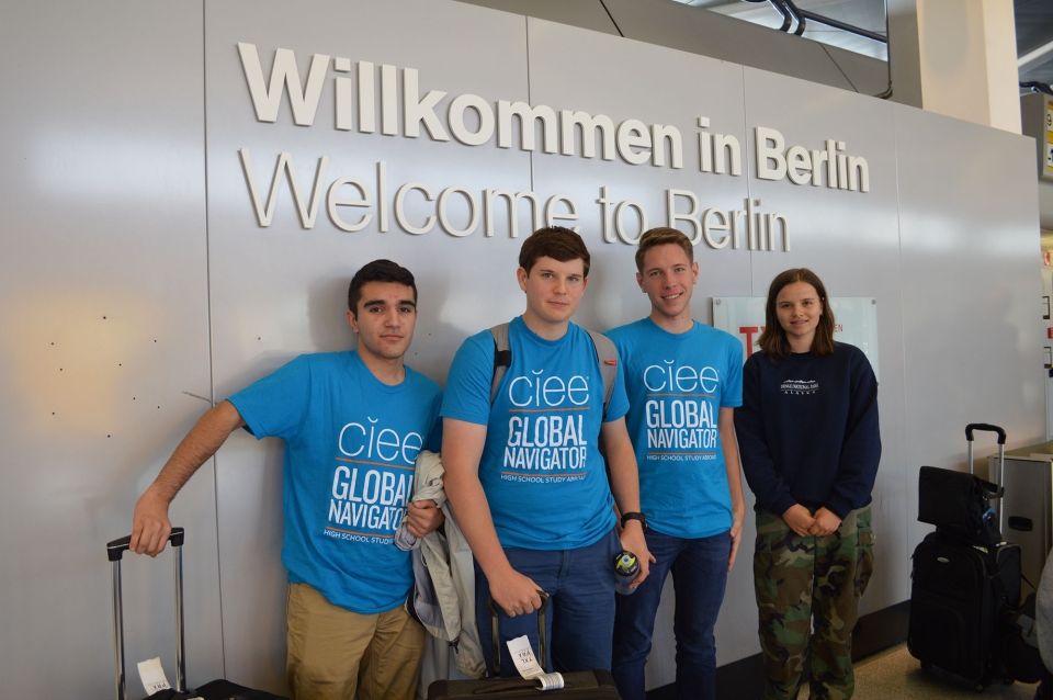 High school students standing in front of Berlin airport sign