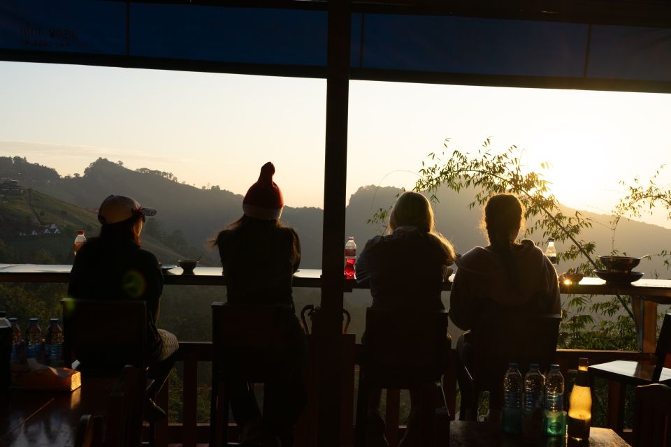 4 girls at a restaurant booth looking at a sunset.