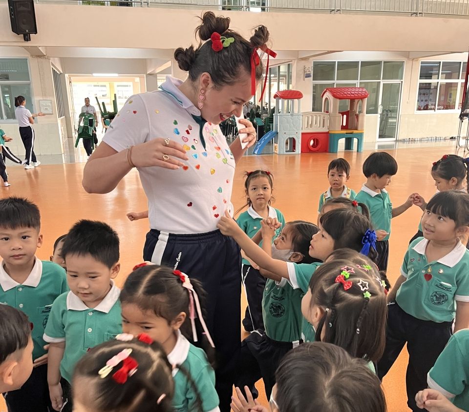 Students put Valentine's Day stickers on a teacher's shirt