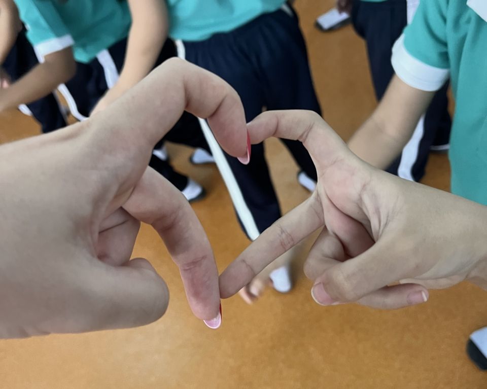 Two people make a hand heart