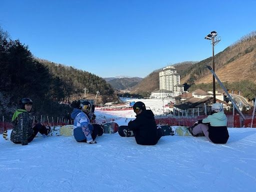 Some friends and I posed with snowboards at the top of the slope