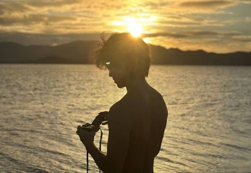 Loading my camera in front of the sunset on starfish island