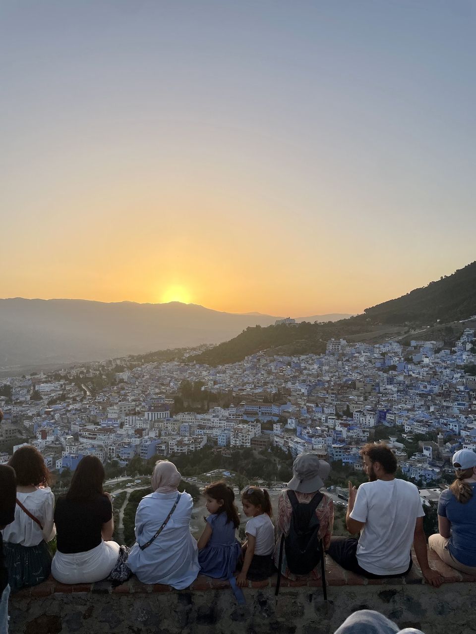 Students sitting on a wall overlooking a city in Morocco