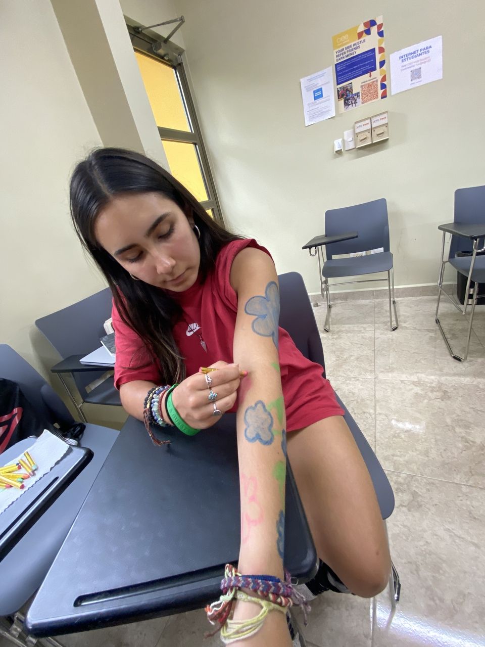 A student doing her art in her arm