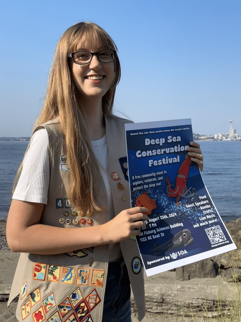 A teenage girl (Ellen) holding a flyer for the Deep Sea Conservation Festival